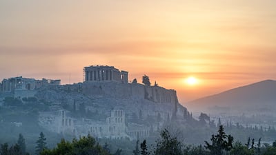 The Parthenon temple on Acropolis hill in Athens is seen through smoke caused by a wildfire north of the Greek capital.