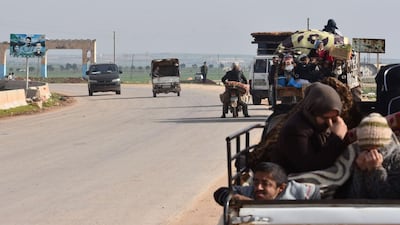 Civilians fleeing the city of Afrin in northern Syria are seen on the back of a pick up truck as they enter the town of Tal Rifaat in the government-controlled part of the northern Aleppo province, on March 18, 2018. George Ourfalian / AFP