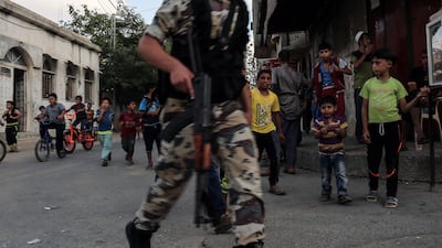 Young boys watch as masked youth cadets from Hamas's armed wing march in the southern Gaza Strip city of Khan Yunis on September 15, 2017. Said Khatib / AFP