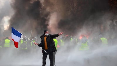 Protesters wearing yellow vests, a symbol of a French drivers' protest against higher fuel prices, are seen during riots on the Champs-Elysees in Paris. Reuters