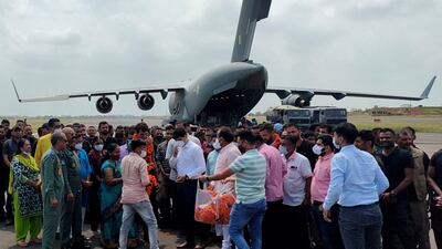 Indian diplomatic staff and their families gather on the runway after their flight from Kabul lands in Jamnagar, western Gujarat state, on its way to Delhi. Reuters