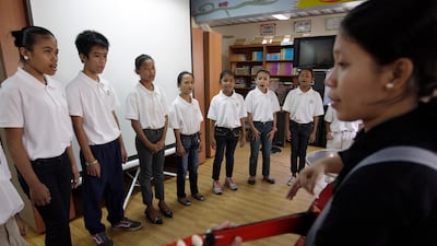 Manila, Philippines, May 10 2013, PCF, Story by The National Reporter Hugo Burger- The PCF Childrens Chorale Group lead by Anita Sarnicula warms up before performing for represenitives From Etihad Airlines who donated , used aircraft blankets, toys, books , school uniforms and one months worth of rice to feed approximately 70 children who attend school at the PCF. Some of the children who reside in the "Smokey Mountain Reclamation Area " located in North Manila, attend the PCF School there. Most children and there families are scanvangers at the smokey Mountain dump. Living conditions are unhealthy, children there suffer from malutrition and substandard living conditions. For The National / Mike Young