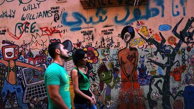 A couple walks by a colorful mural in a fashionable neighborhood in Beirut, Lebanon. Spencer Platt / Getty Images