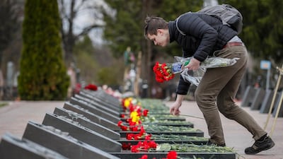 A man places flowers at the tombs of the victims of the Chernobyl nuclear disaster at Mitino cemetery in Moscow, Russia, 26 April 2021, on the 35th anniversary of the tragedy. EPA/YURI KOCHETKOV