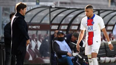 Paris Saint-Germain's French forward Kylian Mbappe (R) passes by coach Mauricio Pochettino after being substituted following his injury. AFP