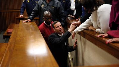 South African Paralympian athlete Oscar Pistorius leaves the High Court in Pretoria after being sentenced to six years in jail for murdering his girlfriend Reeva Steenkamp in 2013. Marco Longari / AFP Photo
