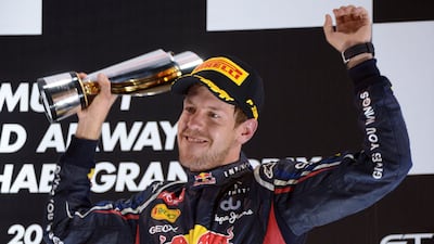 Red Bull Racing's German driver Sebastian Vettel celebrates on the podium at the Yas Marina circuit on November 4, 2012 in Abu Dhabi after the Abu Dhabi Formula One Grand Prix. AFP PHOTO / DIMITAR DILKOFF *** Local Caption *** 818807-01-08.jpg