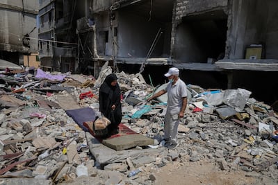 Amira Hejazieh talks to a neighbour amid the rubble of a building destroyed in an Israeli air strike in Tyre, southern Lebanon. Reuters