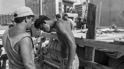 Men take a smoke break while getting ready to load their raft on to a lorry.