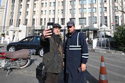 A man takes a selfie with a policeman from the Salvation Government in Damascus. AFP