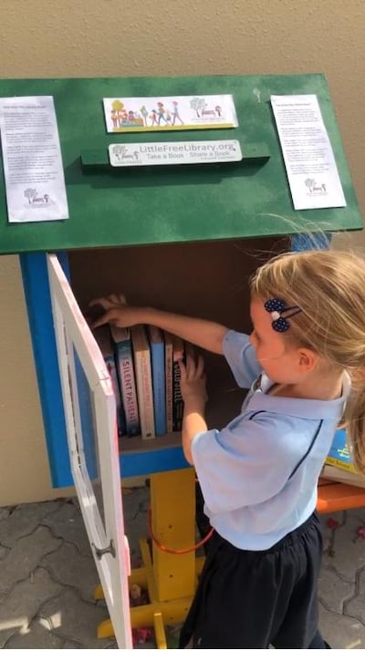 Kelly Harvarde and Alex Jeffries's daughter Aya organising the family's Little Free Library. Harvarde
