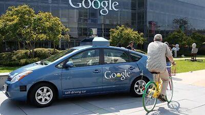 A cyclist passes a Google self-driving car. Such vehicles are a very realistic prospect over the next decade or two. Justin Sullivan / AFP