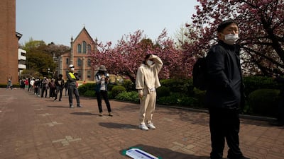 Voters wearing masks maintain social distancing while waiting in line at a polling station during parliamentary elections in Seoul last week. Bloomberg