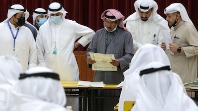 A Kuwaiti judge and his aides count the ballots at a polling station at the end of the parliamentary elections vote, in the Abdullah al-Salem district of Kuwait city. AFP