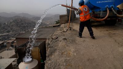 A water lorry worker fills tanks at houses in the Pamplona Alta area in Lima, Peru. Residents buy water for drinking, cooking and cleaning from private suppliers. AP