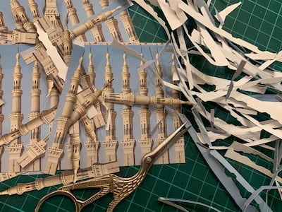 An image of Hadil Moufti's desk, featuring a collage work in progress of a minaret of the Grand Mosque of Madinah, where her father was buried 10 years ago. Courtesy Hadil Moufti