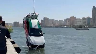 A rescue team lifts the taxi out of Sharjah Creek. Sharjah Civil Defence