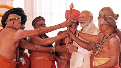 India's Prime Minister Narendra Modi holds the Sengol, a Tamil sceptre, along with priests during the inauguration ceremony of the country's new parliament building in New Delhi on Sunday. AFP