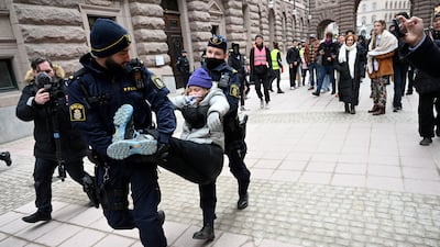 Greta Thunberg is removed by police officers during a demonstration outside the Swedish parliament building, in Stockholm. Reuters