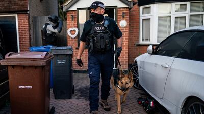 Officers from the National Crime Agency exit a property in Grays, Essex, after arresting a man accused of helping migrants enter the UK illegally. PA