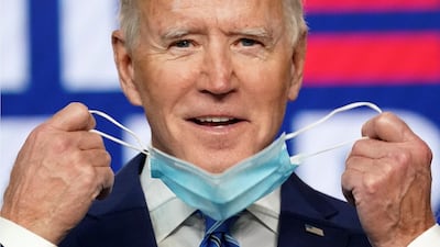 Democratic US presidential nominee and former Vice President Joe Biden smiles as he pulls off his face mask to speak about the results of the election. Reuters