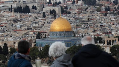 Tourists look at the Old City of Jerusalem and its Dome of the Rock mosque from the Mount of Olives on December 6, 2019. AFP