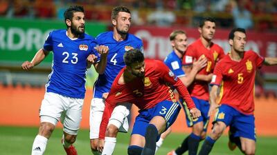Spain defender Gerard Pique in action against Liechtenstein’s Michele Polverino, left, and Daniel Kaufmannin. Eloy Alonso / Reuters