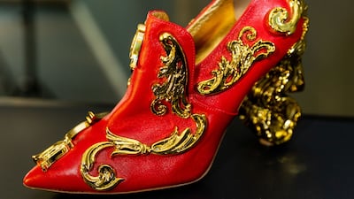 A red satin and golden shoe by Moschino on display in Abu Dhabi. Photo: Italian Cultural Institute