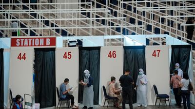 Health staff check at vaccination booths for the coronavirus at a vaccination center in Kuala Lumpur, Malaysia. The country is seeing a surge in coronavirus infections. AP