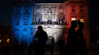 Pedestrians walk past Marseille's town hall lit up in the French Tricolor to honor slain teacher Samuel Paty, Wednesday, October 21, 2020. AP Photo