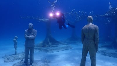 A diver swims near sculptures during the inauguration of the underwater museum in Ayia Napa, Cyprus.