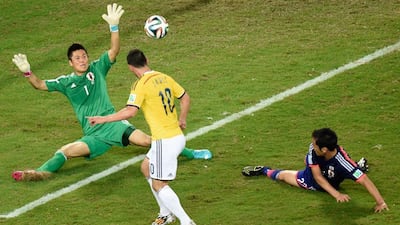 James Rodriguez scores past Japan goalkeeper Eiji Kawashima for Colombia's fourth goal in their 4-1 win on Tuesday at the 2014 World Cup in Cuiaba, Brazil. Juan Barreto / AFP