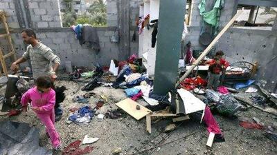 Palestinians survey the scene after Israeli tank fire struck a home in Gaza City on March 23.