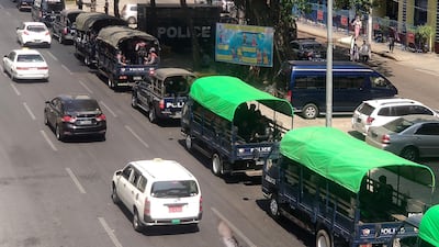Cars pass police sitting in trucks along a road in Yangon, as Myanmar's military detained the country's de facto leader Aung San Suu Kyi and the country's president in a coup. AFP