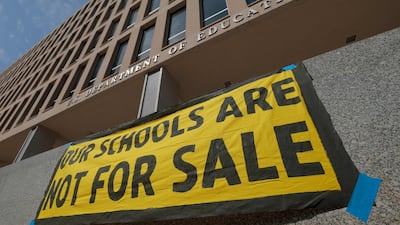Signs from activists with the Sunrise Movement sit outside the US Department of Education on March 20, in Washington. Donald Trump signed an executive order to dissolve the Education Department. Getty