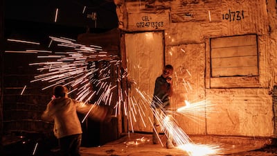Children spin hot steel wool to spread sparks of fire on a street in Nairobi's Kibera slum on New Year's Eve, December 31, 2020. AFP
