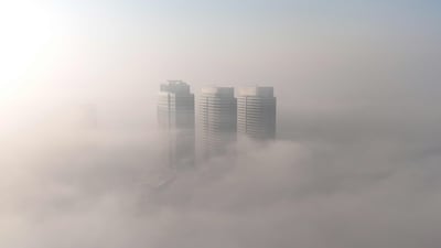 The towers of skyscrapers poke through dense fog in Islamabad, Pakistan. AFP