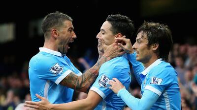 Manchester City’s Samir Nasri, centre, is congratulated by Aleksandar Kolarov, left, after he scored against Everton. Alex Livesey / Getty Images