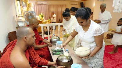 Volunteers serve food to the monks. Two monks are in the UAE at any give time. Chris Whiteoak / The National