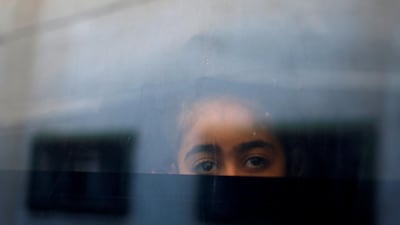 A Palestinian girl looks out a bus window as she waits to cross into Egypt through the Rafah border crossing. Mohammed Salem / Reuters