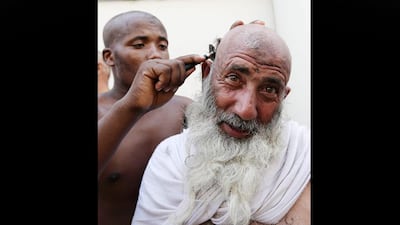 A Muslim has his head ritually shaved after he cast stones at a pillar, symbolising the stoning of Satan. Hassan Ammar / AP Photo