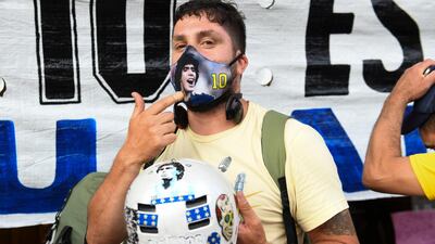 A fan with a Maradona face mask and motorcycle helmet at La Bombonera Stadium in Buenos Aires. Getty