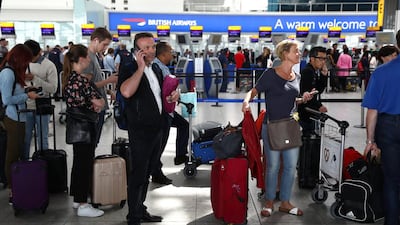 Passengers wait with their luggage at the British Airways check-in desks at Heathrow airport in London. Neil Hall / Reuetrs