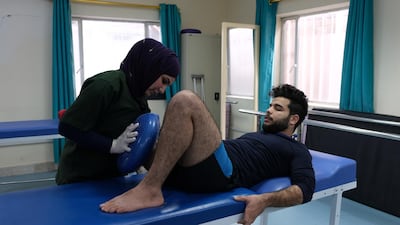 Physiotherapist Ashar Hassan attempts to insensitive Seif Salman's stump, without these exercises, he may be unable to use a prosthetic leg. Ameer Hazim for The National
