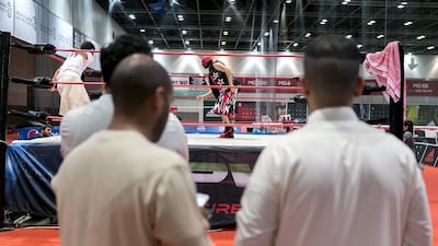 A pair of Emirati men watch a Dubai Pro Wrestling match. The weekly event at Dubai Sports World aims to become the premier wrestling promotion in the region. Reem Mohammed / The National