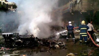 Iraqi firefighters extinguish a fire at the scene of a car bomb attack in Baghdad.