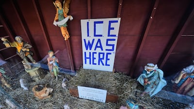An 'ICE WAS HERE' sign is posted in the empty spot for the baby Jesus at a nativity scene at St Susanna Church in Dedham, Massachusetts. AP