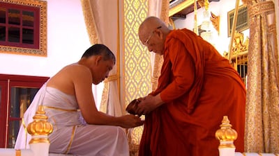 This screengrab shows Thailand's King Maha Vajiralongkorn (left) attending the royal purification ceremony during his coronation in Bangkok. AFP