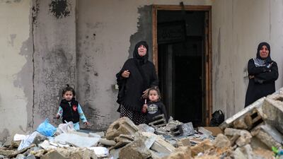 Women and children stand by the rubble of a collapsed building outside Shati camp for Palestinian refugees north of Gaza city. AFP