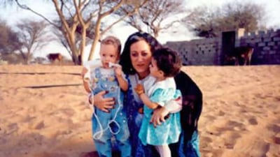 Inocenta Ewert holds her son Edward and Sheikh Sultan's daughter, Shamma, both two and milk siblings, in 1989.